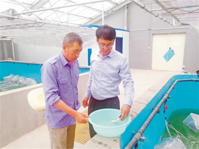 <p>　　王永利（右）指導水產養殖戶進行水質鹽度測試。</p>