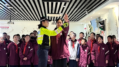 一名同學(xué)在交警的指導(dǎo)下學(xué)習(xí)交通警察指揮手勢。